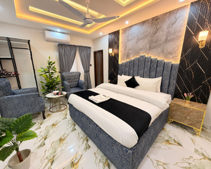 A Hotel Room With A Cozy Bed, A Functional Desk, A Comfortable Chair, A Bright Lamp, And A Stylish Mirror at The Decent Luxury Guest House - 2